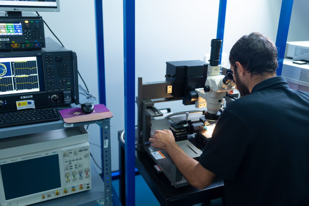 Ingeniero de Celestia Chip realizando análisis y pruebas de microelectrónica con microscopio y equipos de medición